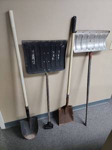 lot 520 image: Shovels - one spade shovel, one square shovel, and two snow scoop shovels (one snow shovel has bends on the corners)