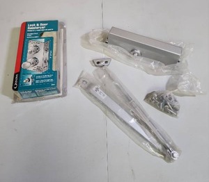 lot 555 image: Ultra Lock & Door Reinforcer Kit (open package, no guarantee all parts are there) and a Commercial Door Closer