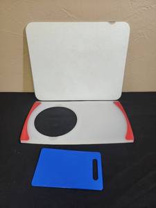 lot 687 image: 3 cutting boards - large glass cutting board (no chips, missing some of the white coloring on the edge), sink cutting board with hole for a bowl (no bowl included), and a small blue cutting board