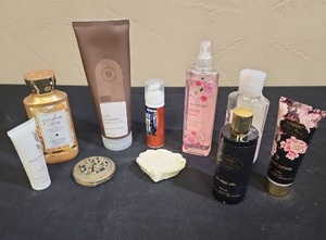 lot 715 image: Mixed Bath and Body Care Products Bundle - lotions and scents, some are partially used, others almost full.  Includes a jeweled compact mirror