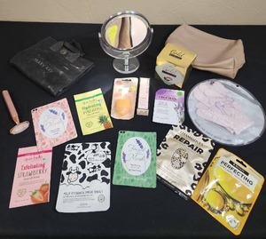 lot 716 image: Beauty and Skincare Product Bundle - includes facial skincare masks, Mary Kay foundation, foundation sponge, exfoliating gloves, vanity mirror, travel bags, and a roller