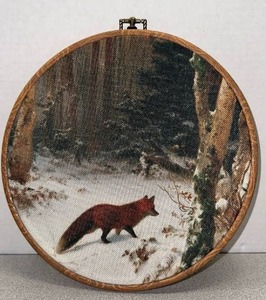 lot 5615 image: 10 inch round fabric wall art print features a vintage-style landscape painting of a fox in a snowy forest.