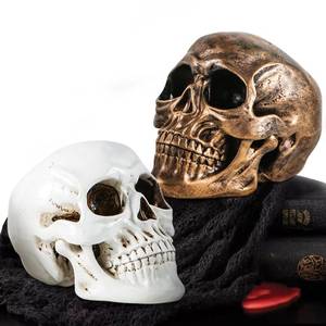 lot 5943 image: Mowtanco Halloween Skull Statues � Set of 2 Resin Skeleton Head Decorations (Gold and White) � 7.7 Realistic Skull Decor for Indoor Halloween Party, Tabletop Centerpiece, Spooky Home Accentsin