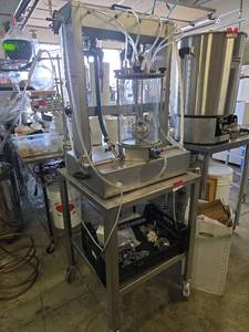 lot 15523 image: Enoitalia 4 bottle filler for 50 ml to 1.75-liter bottles. Includes SS table with casters and tri clamps and fittings.