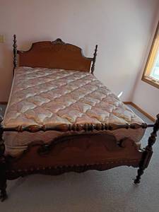lot 201 image: Traditional Full Sized Four Post Bed Frame. Dark Walnut Finish and Scrollwork on Both Headboard and Footboard.  Comes with Slumberon Mattress and Box Springs.  Headboard 50 x 56.   Footboard 40 x 56. Matches lots 202 and 203.  Located Upstairs