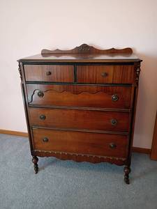 lot 202 image: Tall 5 Drawer Dresser with Decorative Details. Dark Walnut Finish with Scrollwork.  48 x 38 x 20. Matches lots 201 and 203.  Located Upstairs