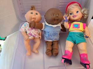 lot 1319 image: 1990s Cabbage Patch Kids and roller blading doll in a plastic hinged bin