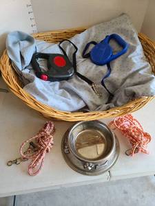 lot 3312 image: Retractable dog leashes, nylon rope leashes,dog bowl, wicker dog bed.