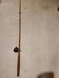 lot 4021 image: Old wooden fishing pole with a Penn reel.