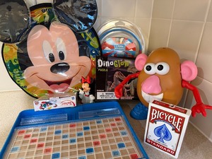 lot 181 image: Disney Backpack w Games, Scrabble Travel Game, ifrogz Headphones, Dino Glow Puzzle and More