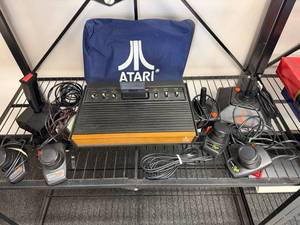 Vintage Atari game console with cords, cover and controllers