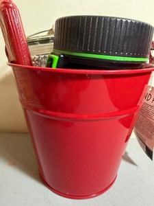 lot 23 image: Red Metal Pail Full of Candles and a Flashlight