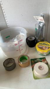 lot 3206 image: Plastic measuring bowl and cups, tape, and zip ties