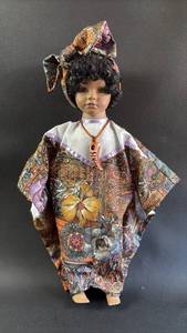 lot 74 image: Porcelain Doll in Traditional African Patterned Outfit