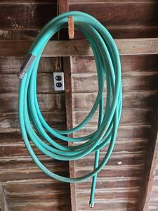 lot 7024 image: Green Garden Hose with Metal Fittings