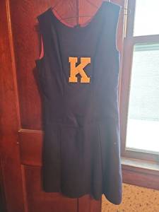 lot 3121 image: This vintage dark navy blue cheerleader uniform features a pleated skirt and a yellow and black K emblem