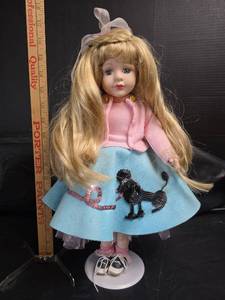 lot 309 image: Blonde Porcelain Doll with Poodle Skirt and Pink Sweater