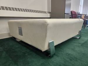 lot 20083 image: Modern Beige Upholstered Ottoman with Chrome Legs and Built-in Power Outlets