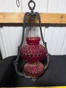 lot 18 image: Cranberry Glass Oil Lamp with Ornate Cast Iron Bracket