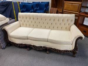 lot 100 image: Traditional style button tufted cream upholstered dark carved wood frame couch34 x 84 x 32 inVERY HEAVY