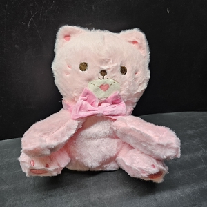 lot 3389 image: Pink plush cat stuffed animal featuring a soft furry texture, embroidered eyes, a pink bow tie, and a small envelope held at its face