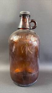 lot 315 image: Brown Glass One Half Gallon Jug with Metal Cap and Loop Handle