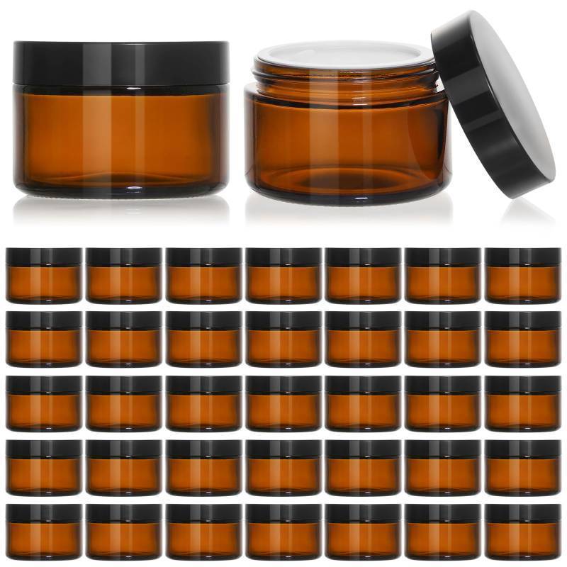 lot 6148 image: KEYWING 1oz Amber Glass Jars with Black Lids, 34 Pack Small Round Glass Cosmetic Jars - Retail $26