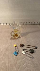 lot 1043 image: Perfume Bottle with vintage diaper Pin Collection