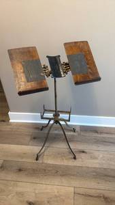 lot 901 image: 19th-century industrial dictionary stand, featuring a sturdy cast-iron base with stylized vine ornamentation and wood book rests 38 x 23 x 16 in