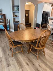 lot 910 image: Oakwood solid oak pedestal dining table 30 x 48 x 48 in with 4 chairs and two 12 inch leaves