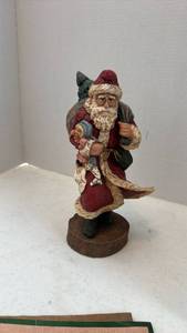 lot 1605 image: Pecan shell wood world Santa figurine carrying tree and toys 9.5 inches tall