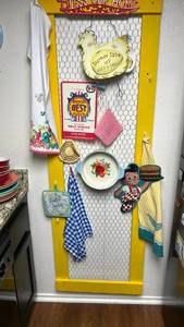 lot 102 image: Yellow Kitchen Display Board with Chicken Wire and Decorative Items 23x75