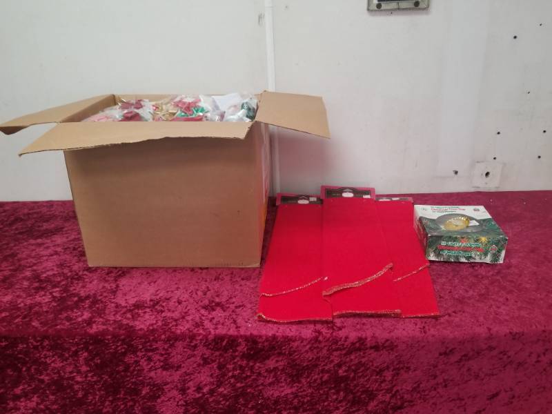 lot 7565 image: Ten Light Christmas Tree Topper, Three Tree Skirts and Case of Bows
