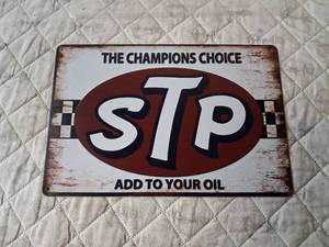 lot 134 image: STP Motor Oil Metal Sign The Champions Choice Add to Your Oil