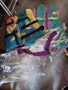 lot 2000 image: Youth 50-90lbs and Adult 30-50in chest life vest and a summer plastic bag