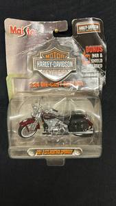 lot 78 image: Maisto Harley-Davidson 2001 FLSTS Heritage Springer 124 Die-Cast Motorcycle with Bonus Bar & Shield