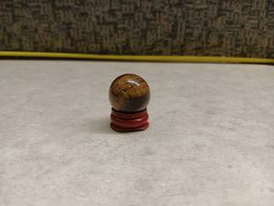 lot 157 image: Tigers Eye Marble with Wooden Stand