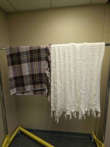 lot 621 image: Two throw blankets with fringe edges - one white knitted blanket and one plaid flannel