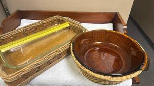 lot 831 image: Clear Pyrex Rectangular Casserole Dish with Wicker Basket that has handles, and an Amber FireKing round casserole dish with wicker basket