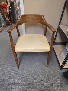 lot 15 image: Mid-Century Wood Arm Chair from Jasper Furniture Co. Some finish wear and light scratches, vinyl slightly discolored. Missing the brass caps on 2 of the legs. 24W x 20D x 30H.  Seat height 18H
