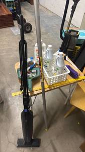 lot 619 image: Bissell Featherweight Vacuum, light bulb changer suction cup pole, cleaning brushes and cleaners