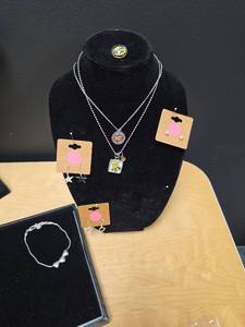 lot 252 image: Silver Tone Jewelry  - Wichita Flag and WSU necklaces, WSU snap front, anklet with hearts, and 3 pairs of earrings