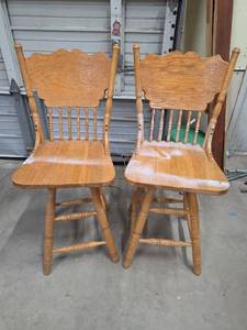 lot 36 image: Carved Back Oak Swivel Bar Stools Chairs Set of 2 - have spray paint on them.  One seat needs tightened otherwise sturdy