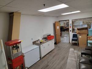 lot 60833 image: Commercial Kitchen Equipment Lot with Chest Freezer and Popcorn Machine - everything in this room except the sink which is attached to the wall and the AC unit in the wall - Retail $500