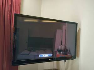 lot 916 image: LG 42in. Television with Remote.  It will need to be taken off wall, so tools will be needed