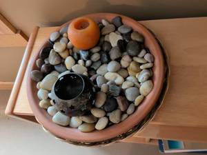 lot 31 image: Terra Cotta Bowl with River Rocks and Star Pattern Tea Light Holder
