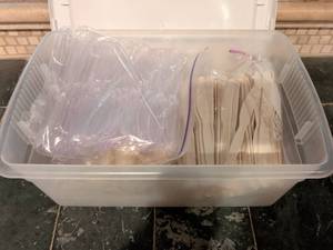 lot 179 image: Clear tub full of plastic spoons, knives