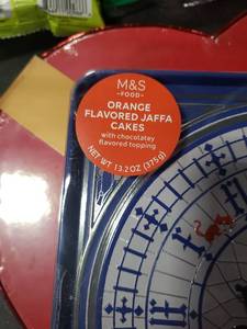 lot 7360 image: M&S Orange Flavored Jaffa Cakes Clock Tin Container