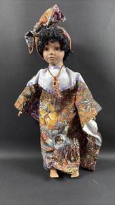 lot 138 image: Porcelain collectible doll featuring a patterned African-inspired outfit and head wrap
