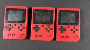 lot 164 image: (3) Merkury Red Portable Handheld Games